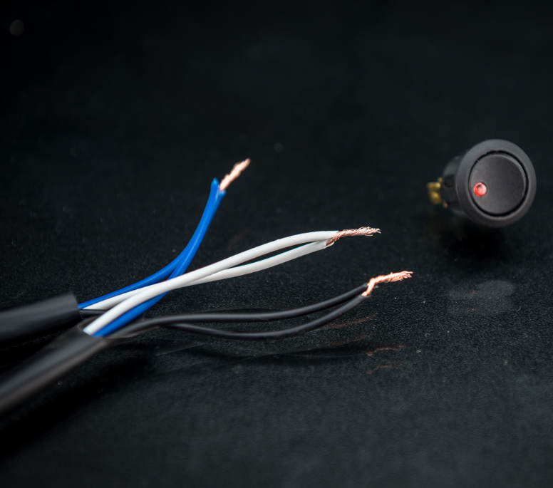 A STEDI™ Piggy Back Adapter, with stripped wire ends, on a black background.